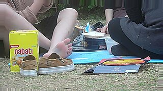 年轻的亚洲女孩在公园里炫耀她的脚