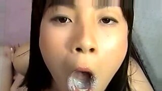 Eine asiatische Schönheit genießt eine intensive Gesichtsbehandlung in einer Bukkake-Orgie.