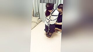 Verführerische asiatische Schönheit wird in BDSM-Spielen geknebelt und gefesselt