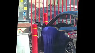 Une blonde plantureuse savonne une voiture, révélant ses courbes dans une scène chaude.