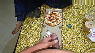Eine indische Frau wird heiß mit kalter Pizza und Fingern.