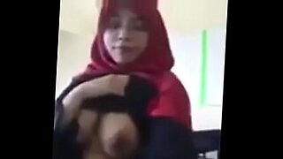 Eine sinnliche, in einen Hijab gekleidete Malaiin zeigt ihren üppigen Busen.