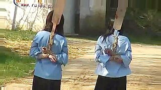 Mulheres chinesas amarradas se submetem à dominação ao ar livre.