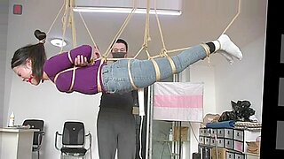 Chinese beauty suspended upside down, gagged and powerless.