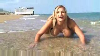 Busty Ευρωπαία Carol Goldnerova απολαμβάνει να παίζει με το στήθος της σε μια γυμνή παραλία.